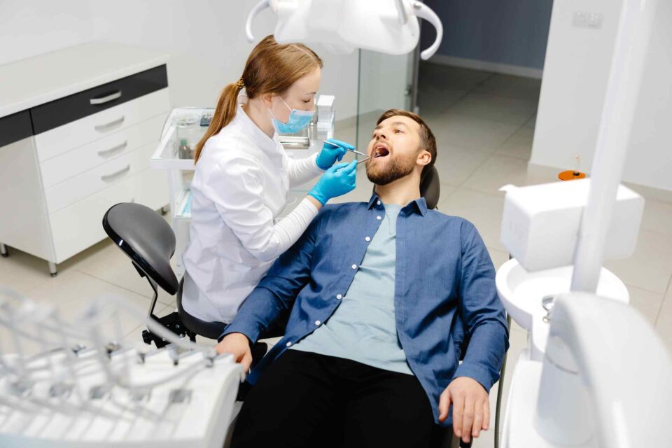 A dental professional performing a routine dental examination on a patient in Wheaton, IL