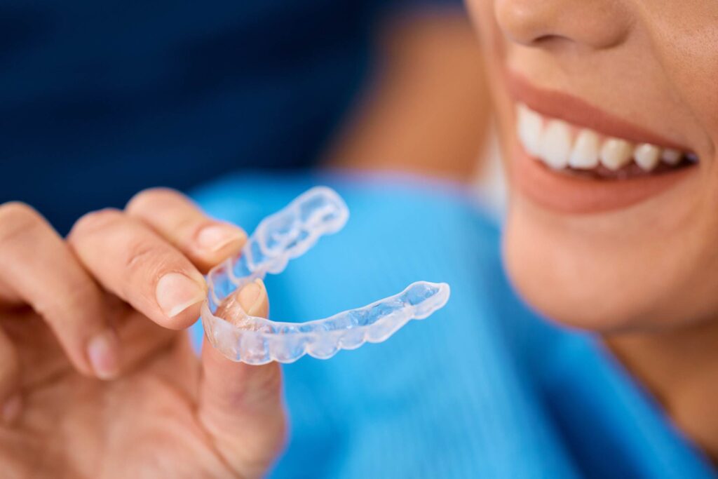 Woman smiling with straight teeth after Invisalign treatment in Wheaton, IL