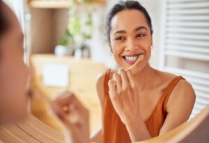 A woman brushes her teeth, promoting the importance of choosing the right toothbrush in Wheaton, IL