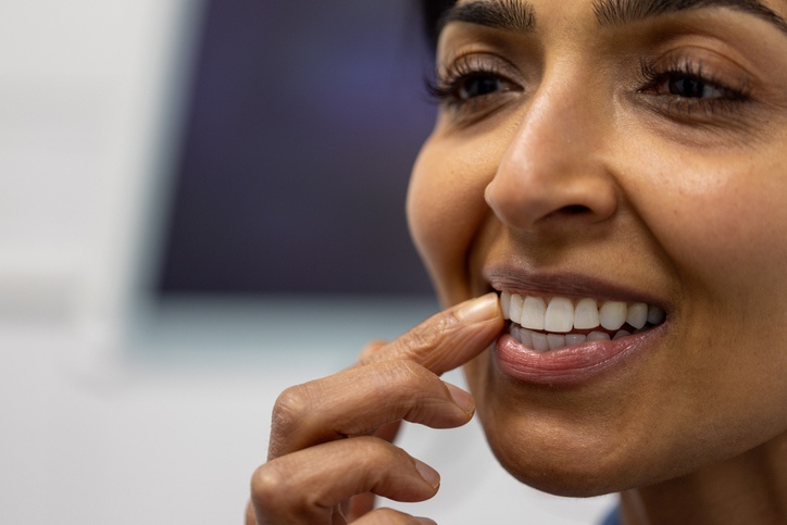 A person touching a tooth because of tooth sensitivity discomfort in Wheaton, IL